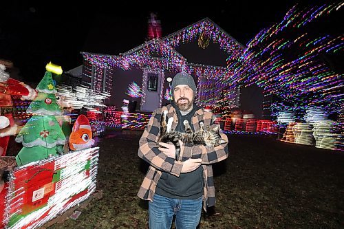 07122023
Patrick Stewart and his cat Ezra outside their brightly decorated and lit-up home at 522 22nd Street in Brandon on Thursday evening. Stewart and his family are asking for donations from visitors to the light show for Paws Crossed Animal Rescue.
(Tim Smith/The Brandon Sun)