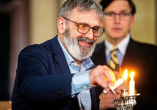 MIKAELA MACKENZIE / WINNIPEG FREE PRESS
	
Gavin Rich lights the menorah at the Manitoba Legislative Building on Thursday, Dec. 7, 2023. 
Winnipeg Free Press 2023