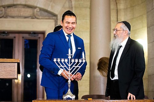 MIKAELA MACKENZIE / WINNIPEG FREE PRESS
	
Premier Wab Kinew (left) laughs with rabbi Avrohom Altein before lighting the shamash at the lighting of the menorah at the Manitoba Legislative Building on Thursday, Dec. 7, 2023. 
Winnipeg Free Press 2023