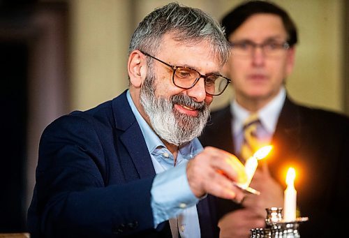 MIKAELA MACKENZIE / WINNIPEG FREE PRESS
	
Gavin Rich lights the menorah at the Manitoba Legislative Building on Thursday, Dec. 7, 2023. 
Winnipeg Free Press 2023