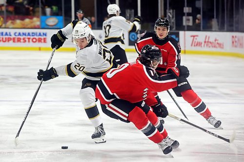 Hayden Wheddon of the Brandon Wheat Kings plays the puck past Connor Schmidt of the Moose Jaw Warriors during WHL action at Westoba Place on Friday evening. (Tim Smith/The Brandon Sun)