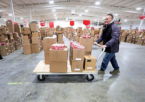 RUTH BONNEVILLE / WINNIPEG FREE PRESS

Local - First Delivery of Christmas Cheer hampers

 Yuri Spirkin pushes a load  of Christmas hampers toward the loading ramp where they will be loaded into a vehicle to be delivered Friday.  Spirkin and his colleagues, Christian Atupan and Max Ewaschuk (not in this photo) from Wawanesa group, were the first delivery crew of the year with hundreds of crews to follow in the coming days and weeks. 

Dec 8th,  2023