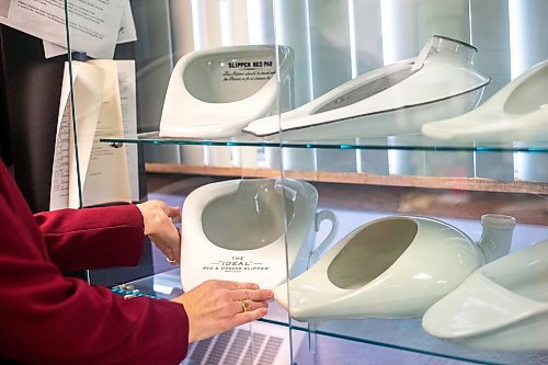 MIKAELA MACKENZIE / WINNIPEG FREE PRESS
	
Archivist Emma Prescott holds one of a small collection of bedpans at the Health Science&#x573; Centre archives on Monday, Dec. 11, 2023. Students at Brandon University took the bedpans on as research projects. For Dave Sanderson story.
Winnipeg Free Press 2023