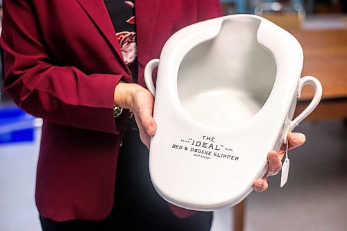 MIKAELA MACKENZIE / WINNIPEG FREE PRESS
	
Archivist Emma Prescott holds one of a small collection of bedpans at the Health Science&#x573; Centre archives on Monday, Dec. 11, 2023. Students at Brandon University took the bedpans on as research projects. For Dave Sanderson story.
Winnipeg Free Press 2023