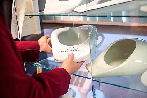 MIKAELA MACKENZIE / WINNIPEG FREE PRESS
	
Archivist Emma Prescott holds one of a small collection of bedpans at the Health Science&#x573; Centre archives on Monday, Dec. 11, 2023. Students at Brandon University took the bedpans on as research projects. For Dave Sanderson story.
Winnipeg Free Press 2023