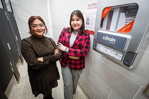 JOHN WOODS / WINNIPEG FREE PRESS
University of Winnipeg Student Association (UWSA) president Tomiris Kaliyeva, right, and Christine Quiah, VP of student affairs, are photographed with one of their menstrual pad, tampon and other menstrual product dispensers in a bathroom on campus Monday, December 11, 2023. The University of Winnipeg is the latest campus making pads, tampons and other menstrual products free of charge to students, staff and passersby.

Reporter: maggie