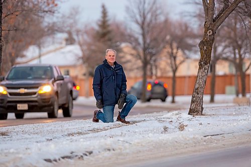 BROOK JONES / WINNIPEG FREE PRESS
Island Lakes Residents Group chair Lindsey Wilson, who has lived in Island Lakes with his wife since Dec. 19, 1986, kneels next tracks in the snow where a vehicle jumped in curb and drove onto the median. The. 71-year-old, who is concerned about the slippery and ice conditions of the roads in Island Lakes, is pictured along Island Shore Boulevard between Waterside Cove and Island Cove in. Winnipeg, Man., on the afternoon of Wednesday, Dec. 13, 2023.