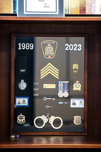 MIKAELA MACKENZIE / WINNIPEG FREE PRESS
	
A shadow box with mementos of his time as a police officer in Robert Chrismas&#x560;office at City Hall on Wednesday, Dec. 13, 2023. For Tyler story.
Winnipeg Free Press 2023