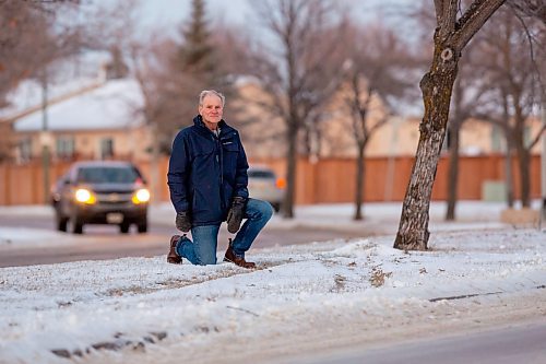 BROOK JONES / WINNIPEG FREE PRESS
Island Lakes Residents Group chair Lindsey Wilson, who has lived in Island Lakes with his wife since Dec. 19, 1986, kneels next tracks in the snow where a vehicle jumped in curb and drove onto the median. The. 71-year-old, who is concerned about the slippery and ice conditions of the roads in Island Lakes, is pictured along Island Shore Boulevard between Waterside Cove and Island Cove in. Winnipeg, Man., on the afternoon of Wednesday, Dec. 13, 2023.