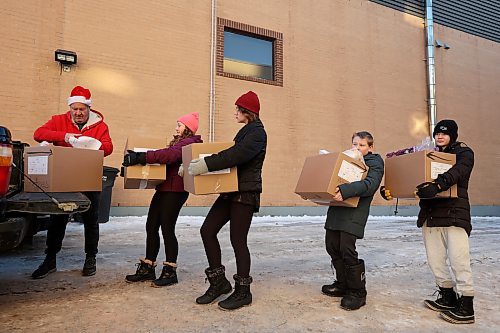 Grade 7-8 students from Oak Lake Community School help load Christmas hampers into waiting vehicles while volunteering at the Brandon & Westman Christmas Cheer Registry on Thursday. Volunteers fanned out across Westman on Wednesday and Thursday to deliver hampers. (Photos by Tim Smith/The Brandon Sun)