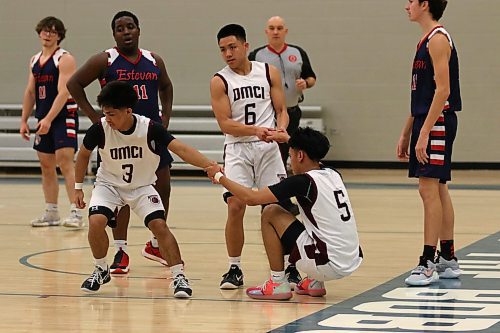 Daniel McIntyre Maroons Caden Tugade (3) and Tyson Francisco help Kian Laurel off the floor during their opening game of the BSSI against Estevan. (Thomas Friesen/The Brandon Sun)
