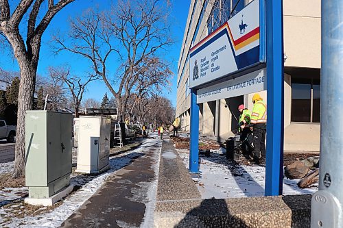 Contractors work to clear hedges and greenery from the perimeter of RCMP's D Division headquarters on Dec. 14, 2023, in an effort to improve sightlines for security cameras and deter potential property crimes. (Tyler Searle / Winnipeg Free Press)