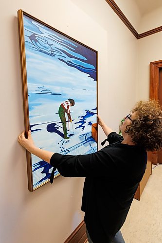 MIKE DEAL / WINNIPEG FREE PRESS
Amy Karlinsky, Visual Arts Consultant, Sport Culture Heritage and Tourism, and a staff member hang a painting by Ilona Stanley, titled &#x201c;Winter Wind,&#x201d; in Minister of Health, Seniors and Long-Term Care, Uzoma Asagwara&#x2019;s office.
231207 - Thursday, December 07, 2023.