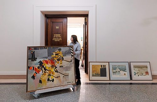 MIKE DEAL / WINNIPEG FREE PRESS
Hanna Ferris a STEP service employee (STudent Employment Placement), one of two who work in the provincial art collection department, moves a couple of Gordon Adaskin paintings, Hockey Series #1 and #2, through the Manitoba Legislative Building. 
231212 - Tuesday, December 12, 2023.