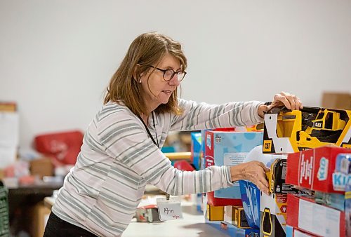 BROOK JONES / WINNIPEG FREE PRESS
Volunteer Ann Radons, who wraps toys for children, helps sort the toys at the Christmas Cheer Board at 895 Century St., in Winnipeg, Man., Friday, Dec. 15, 2023.  The Christmas Cheer Board was established in Winnipeg in 1919.