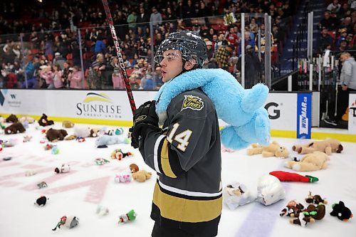 16122023
Jayden Wiens #14 of the Brandon Wheat Kings collects stuffed toys after the Wheaties scored their first goal against the Moose Jaw Warriors during Teddy Bear Toss night at Westoba Place on Saturday evening. The collected stuffed animals go to the Brandon-Westman Christmas Cheer Registry and the Westman Traditional Christmas Dinner. Fans also donated warm clothing, gifts and non-perishable goods. (Tim Smith/The Brandon Sun)