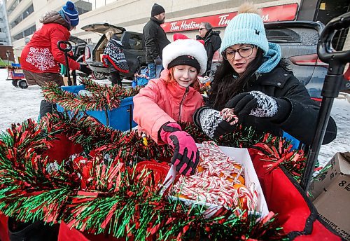 JOHN WOODS / WINNIPEG FREE PRESS
Keila Anobis, executive director of Urban Wagons and her daughter Hazel, 9, and other volunteers get their wagons ready before they head out to hand out Christmas goodies and gifts to people on Graham Avenue in Winnipeg Sunday, December 17, 2023. 

Reporter: gabby