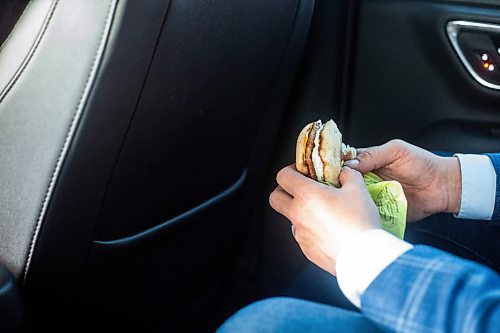 MIKAELA MACKENZIE / WINNIPEG FREE PRESS
	
Wab Kinew eats a sausage and egg McMuffin on the way to work on Friday, Dec. 15, 2023. For Maggie story.
Winnipeg Free Press 2023