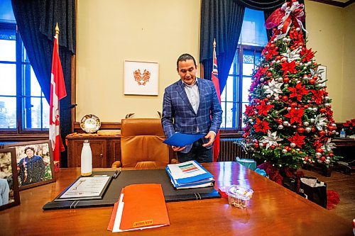 MIKAELA MACKENZIE / WINNIPEG FREE PRESS
	
Wab Kinew looks at folders laid out on his desk first thing at his office on Friday, Dec. 15, 2023. For Maggie story.
Winnipeg Free Press 2023