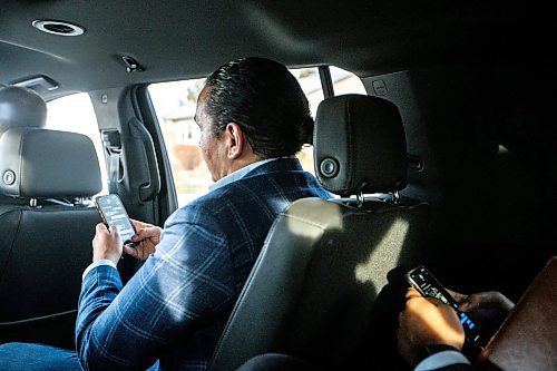 MIKAELA MACKENZIE / WINNIPEG FREE PRESS
	
Wab Kinew and special assistant Seeon Smith (in the back seat) text while on their way to the Canada Goose factory on Friday, Dec. 15, 2023. For Maggie story.
Winnipeg Free Press 2023