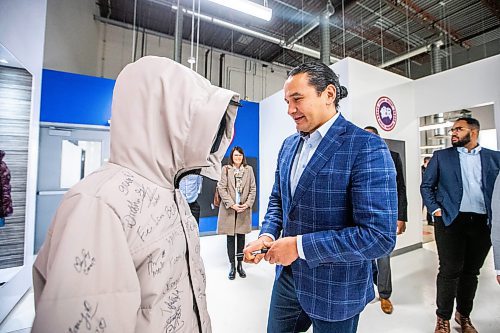 MIKAELA MACKENZIE / WINNIPEG FREE PRESS
	
Wab Kinew signs a parka at the Canada Goose factory on Friday, Dec. 15, 2023. For Maggie story.
Winnipeg Free Press 2023