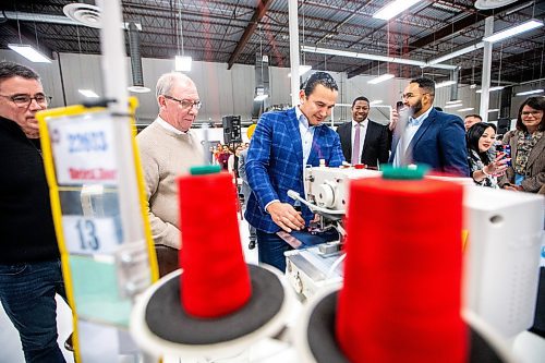 MIKAELA MACKENZIE / WINNIPEG FREE PRESS
	
Wab Kinew tries his hand at sewing a patch during a tour of the Canada Goose factory on Friday, Dec. 15, 2023. For Maggie story.
Winnipeg Free Press 2023