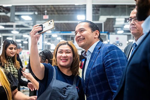 MIKAELA MACKENZIE / WINNIPEG FREE PRESS
	
Wab Kinew takes a selfie with employee Catherine Andrin during a tour of the Canada Goose factory on Friday, Dec. 15, 2023. For Maggie story.
Winnipeg Free Press 2023