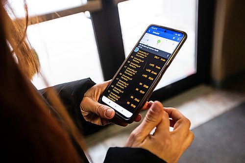 MIKAELA MACKENZIE / WINNIPEG FREE PRESS
	
Venera Sorkina checks the transit app before heading out to take the bus back home from Mosaic's English language class on Monday, Dec. 11, 2023. For Malak story.
Winnipeg Free Press 2023