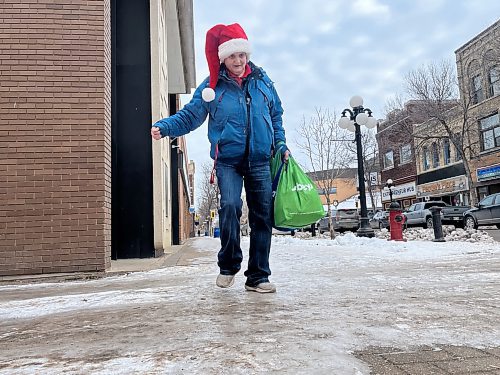 Brandon's Katherine Davis steps carefully on the ice-covered sidewalk along Rosser Avenue on Tuesday afternoon. (Michele McDougall/The Brandon Sun)