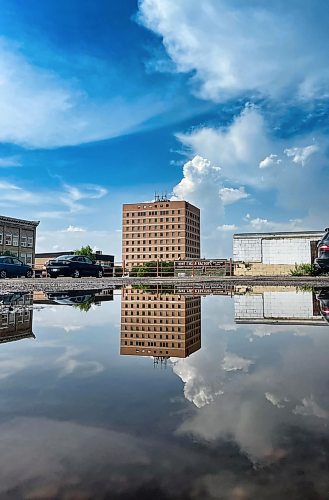 The Scotia Tower building on Rosser is refleced in a giant puddle on a parking lot along Princess Avenue following a spring rainfall this year. (Matt Goerzen/The Brandon Sun)