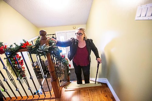 MIKAELA MACKENZIE / WINNIPEG FREE PRESS
	
Joanne Machado, who needs a hip replacement but was two weeks too late to get a surgery via the out-of-province task force (and is now facing a year wait), climbs the stairs in her home with difficulty on Friday, Dec. 22, 2023. For Katie story.
Winnipeg Free Press 2023