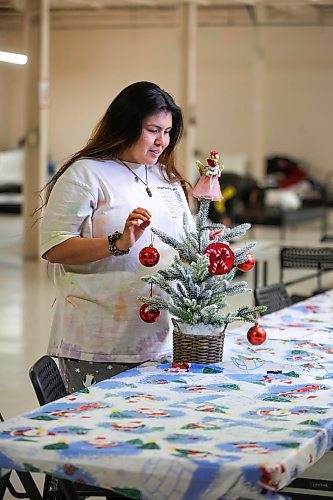 RUTH BONNEVILLE / WINNIPEG FREE PRESS

Local -  N'Dinawemak 

Feature pm  N'Dinawemak &#x460;Our Relatives' Place at 190 Disraeli Freeway and some of their clients that have become volunteers at the centre.  

Portrait of Kyla Ouskun, who volunteers her time cleaning washrooms and helping out wherever she can at the centre,  

Photo taken upstairs, in the women's dormitory as she enjoys dressing a small, tabletop, Christmas tree decoration on their dining table in their dormitory Thursday. 
 
Feature by Niigaan 

Dec 21st,  2023