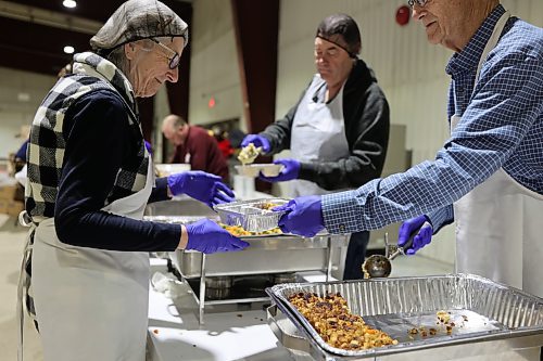 Volunteers in the Manitoba Room fill take-out containers of turkey and fixings for delivery around town. About 1,500 takeout orders were placed in advance of the day. (Geena Mortfield/The Brandon Sun)