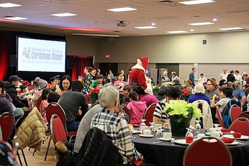 Santa hands out candy canes to children during the 38th annual Westman and area traditional Christmas dinner on Monday. (Geena Mortfield/The Brandon Sun)