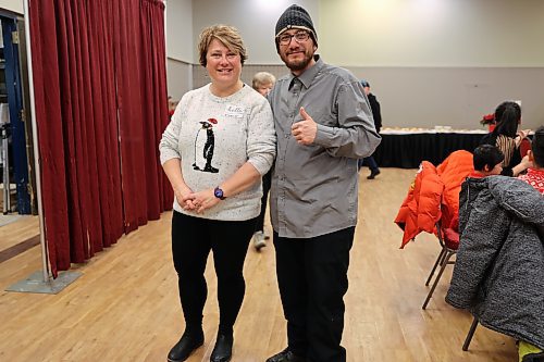 Doug Hiebert poses with a volunteer during his first time attending the volunteer-led dinner on Christmas Day. (Geena Mortfield/The Brandon Sun)