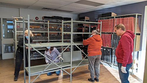 Volunteers disassemble shelves at the old Brandon Sun building's archive room on Rosser Avenue in October. When the building was sold, representatives from local museums and volunteers worked to save the archives from being thrown in the landfill by moving them to a temporary home at the Commonwealth Air Training Plan Museum. (Submitted)