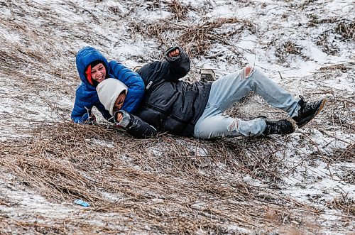 JOHN WOODS / WINNIPEG FREE PRESS
Friends Mavo, left, and Dustin wipeout as they slide down Garbage Hill at Westvew Park in Winnipeg Tuesday, December  26, 2023. 

Reporter: standup