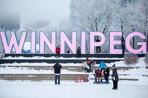 Daniel Crump / Winnipeg Free Press. People gather at the Winnipeg sign at the Forks in Winnipeg on New Year&#x573; Eve. December 31, 2022.