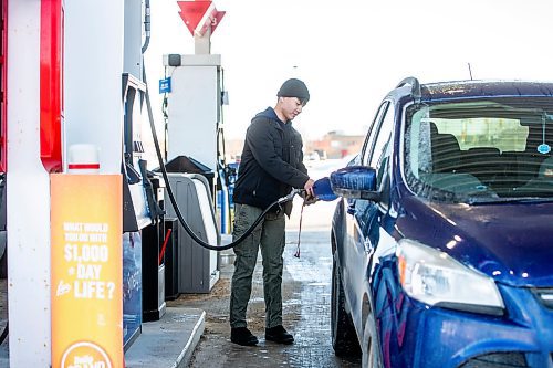 MIKAELA MACKENZIE / WINNIPEG FREE PRESS
	
Tony Huynh fills up his tank at the Polo Park Mobil gas station on Friday, Dec. 29, 2023. The gas tax will be paused on Jan. 1st, which should further reduce gas prices. For Danielle story.
Winnipeg Free Press 2023