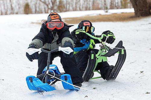 03012024
Theo Durnin and Jason Cory are pulled through the snow on sleds by Jason’s dad Ken using a quad at the Corys' home near Wawanesa on a mild and overcast Wednesday.
(Tim Smith/The Brandon Sun)