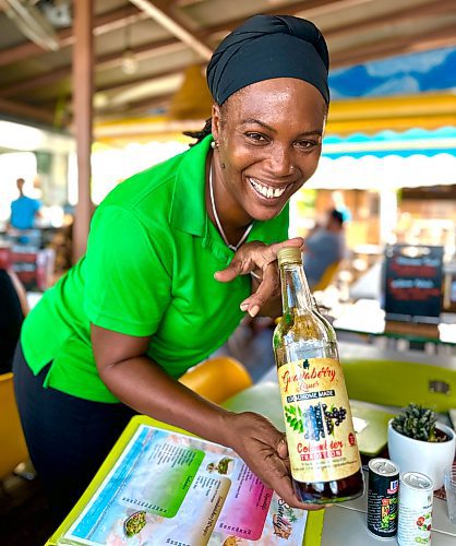 Shel Zolkewich / Winnipeg Free Press
The always-smiling Sandrine of Sandy’s lolo in Marigot shows off the local specialty, guavaberry liqueur. 