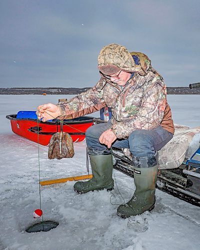 Roger Boulet of Brandon sits atop his 1994 Yamaha Bravo snowmobile while ice-fishing at Pelican Lake with his daughter Genevieve Boulet on a mild and overcast day. For more photos see Page XX
(Tim Smith/The Brandon Sun)