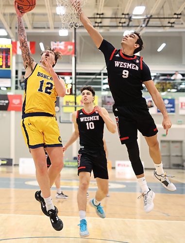 Jack McDonald (12) of the Brandon University Bobcats leaps to take a shot on the net as Alberto Gordo (9) of the University of Winnipeg Wesmen tries to block the shot during university basketball action at the BU Healthy Living Centre on Friday evening. (Tim Smith/The Brandon Sun)