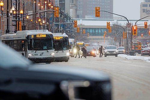 MIKE DEAL / WINNIPEG FREE PRESS
People cross Portage Avenue during morning rush hour as snow fall is expected to pick up. Fifteen centimetres of snow is predicted for Winnipeg between tonight and Thursday, with temperatures dipping to nearly -30 C overnight Thursday into Friday.
240110 - Wednesday, January 10, 2024.