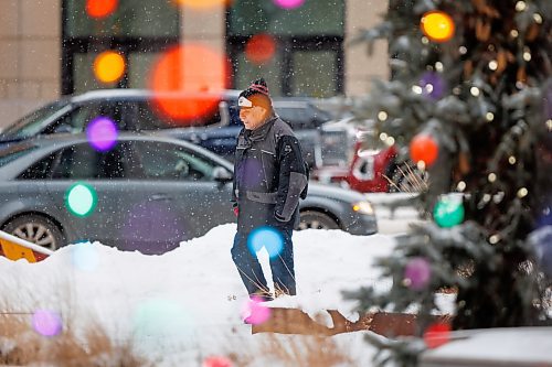 MIKE DEAL / WINNIPEG FREE PRESS
A pedestrian walks through light snowfall by the Richardson Building at Portage and Main during rush hour. Fifteen centimetres of snow is predicted for Winnipeg between tonight and Thursday, with temperatures dipping to nearly -30 C overnight Thursday into Friday.
240110 - Wednesday, January 10, 2024.