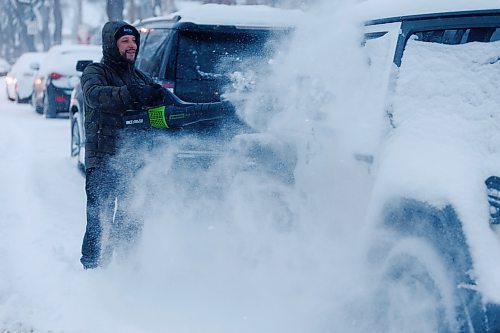 MIKE DEAL / WINNIPEG FREE PRESS
Jamie Muzik clears off his neighbours vehicle on Ruby Street Thursday morning with a leaf blower after about 15 cm of snow fell overnight.
240111 - Thursday, January 11, 2024.