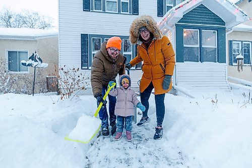 MIKE DEAL / WINNIPEG FREE PRESS
David and Laura Noel-Romas clear snow off of their front walk on Sherburn Street, with daughter, Josephine, 2, Thursday morning.
240111 - Thursday, January 11, 2024.