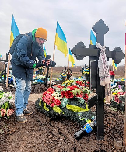 MELISSA MARTIN / WINNIPEG FREE PRESS

Olexiy Ladyka takes video to share with Kramatorsk Post&#x2019;s TikTok followers, at the military cemetery near Kramatorsk. A follower had asked Ladyka to visit their friend&#x2019;s grave and leave a pack of cigarettes, a bottle of Pepsi, and a Snickers bar. January 6, 2024. 

Ukraine feature - 2024