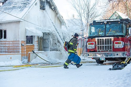 BROOK JONES / WINNIPEG FREE PRESS
Firefighters with Winnipeg Fire Paramedic Service responded to a fire in a two-and-a-half-storey multi-family house in the 100 block of Rex Avenue in Winnipeg, Man., around 11:20 a.m., Sunday, Jan. 14, 2024. By 3:30 p.m. crews were clearing the scene as the house, which was seriously damaged by fire, continued to smolder. Pictured: A firefighter packs up gear. 