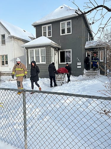 First responders remove a body from a home at 381 College Ave. Jan. 16, 2024, after a fire broke out early in the morning, killing one person and injuring two others (Tyler Searle / Winnipeg Free Press)